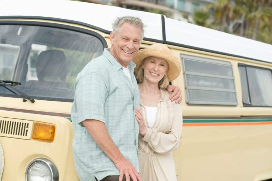 Vibrant retired, grey nomads in front of their combi van. Discover the security and freedom of Over 50s Lifestyle Homes for Retirement